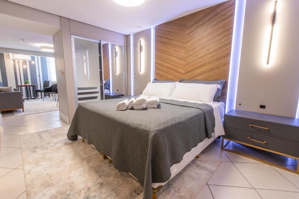 Delupo Apart Hotel في كريسيوما: غرفة نوم عليها سرير وحذيين