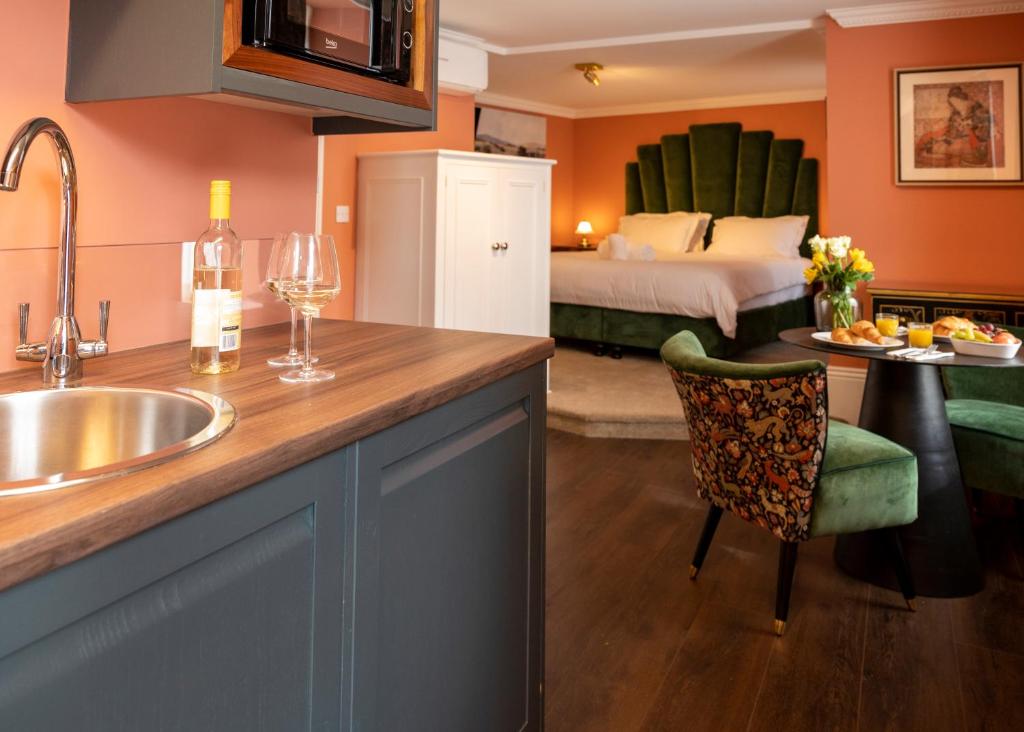a kitchen with a sink and a bedroom with a bed at The Fanny Talbot in Barmouth