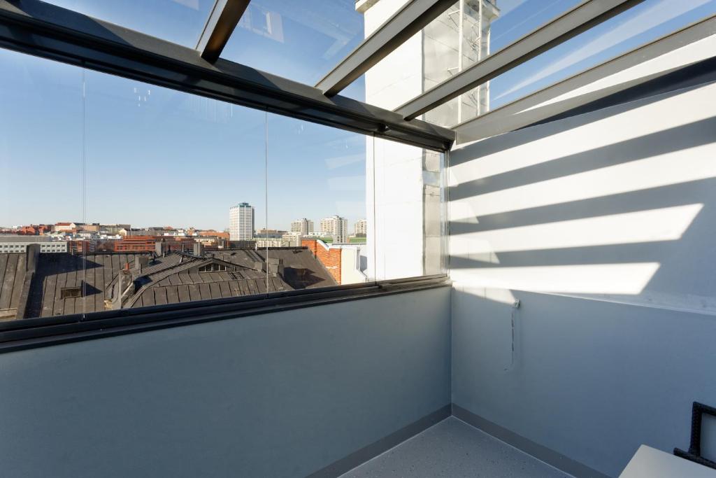a room with a large window with a view of the city at Forenom Serviced Apartments Helsinki Kruununhaka in Helsinki