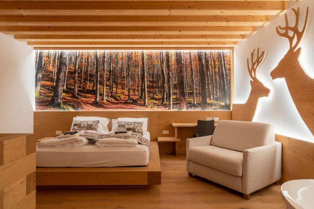 - une chambre avec un lit, une chaise et un tableau dans l'établissement Casera Cal De Mez- Wellness Chalet, 