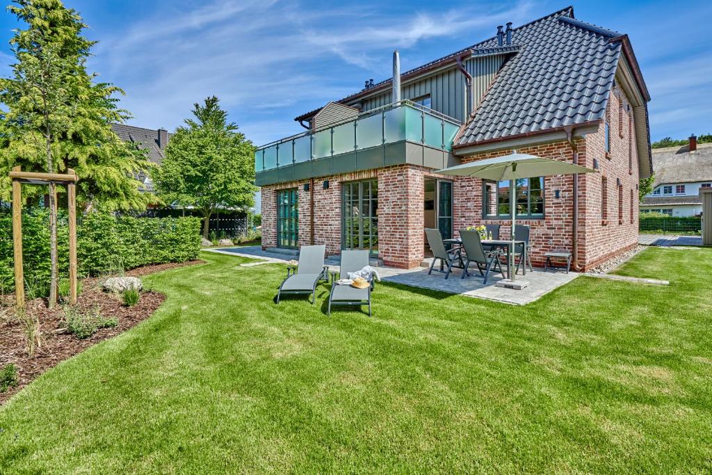 青斯特FeWo Brede Zingst的一个带雨伞的砖屋的院子