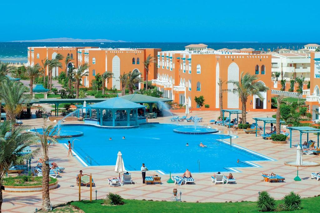 Sunrise Garden Beach Resort في الغردقة: منتجع فيه مسبح كبير وفيه ناس