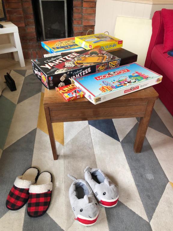 a table with a pile of books and shoes at La plage au bout du jardin &#47; Sword Beach cottage in Hermanville-sur-Mer