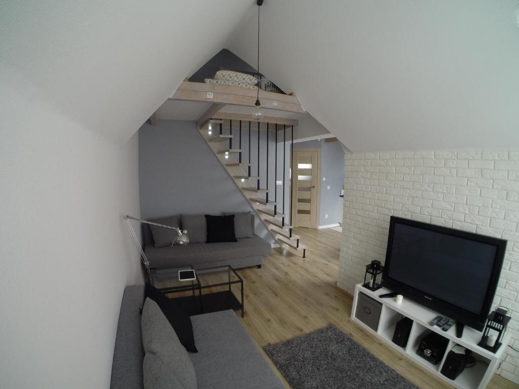 sala de estar con escalera y TV en Studio Stroma Zakopane, en Zakopane