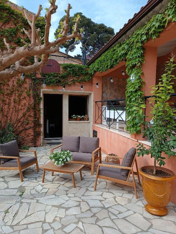 a patio with chairs and a table and a tree at Aux Berges du Canal in Capestang