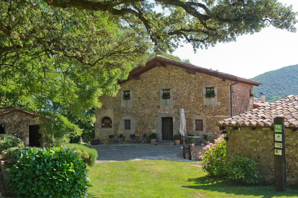 a large stone house with a large yard at Mas Molera Turisme Rural in Sant Joan les Fonts