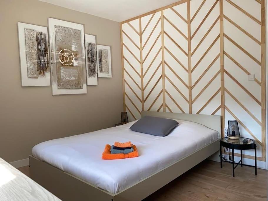 沃伊皮的住宿－Le Cosy 120m² - 4 chambres - 8 personnes，一间卧室配有一张带橙色毛巾的床