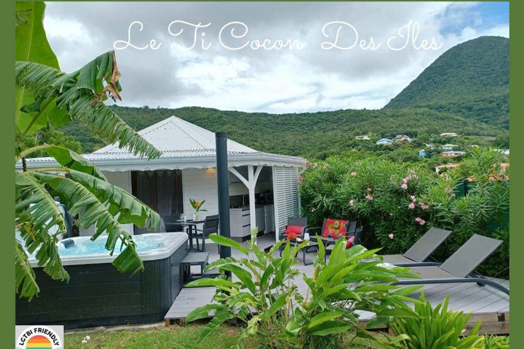 a house with a hot tub and chairs and mountains at Ti Cocon Des Iles, Bungalow de Charme Spa Privatif in Quartier du Fond Fleuri