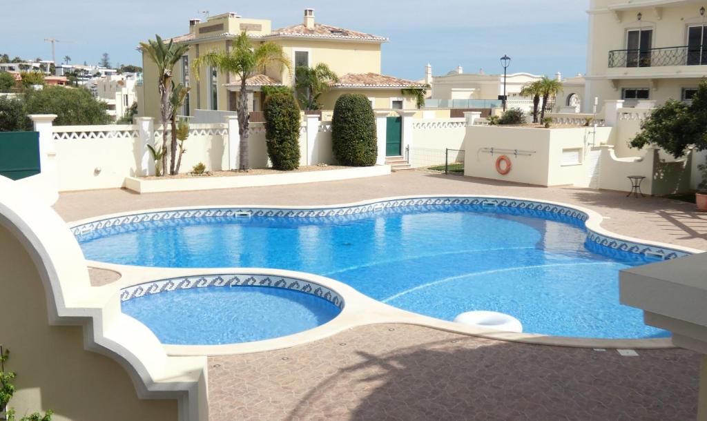 a swimming pool in front of a villa at Apartamento Íris in Lagos