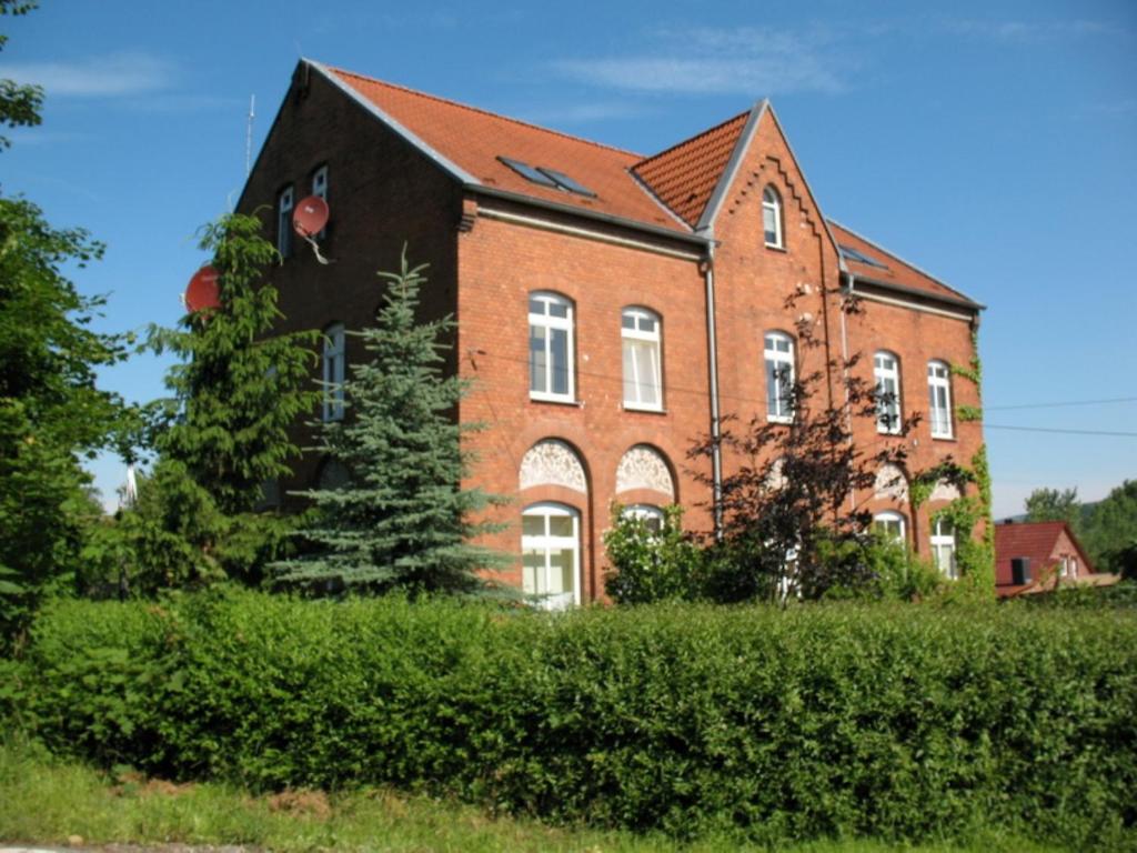 ein großes Backsteingebäude mit einem Baum davor in der Unterkunft Ferienwohnung Barbarossa in Rottleben