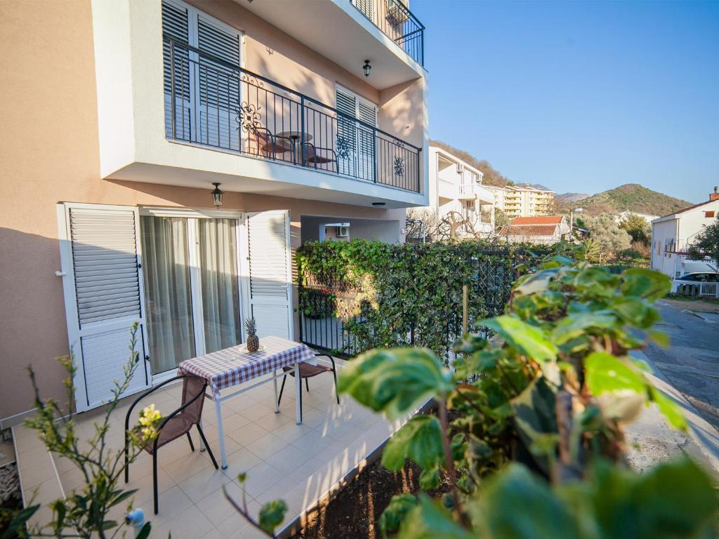 a balcony with a table and chairs in front of a building at Guest House 4M in Petrovac na Moru