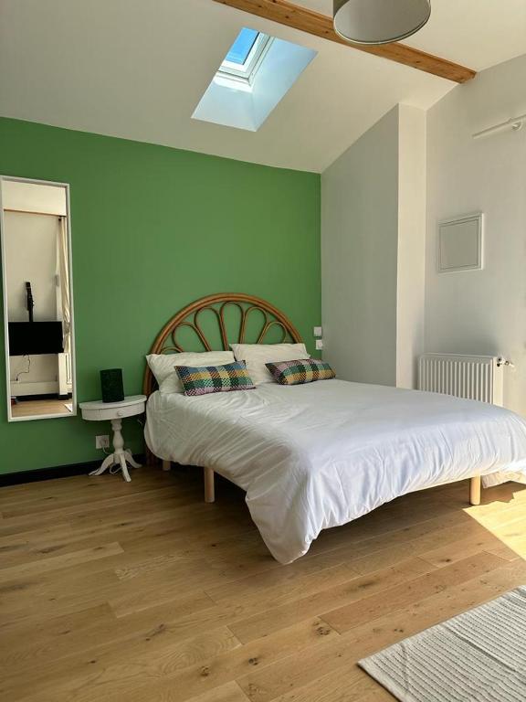 sypialnia z dużym łóżkiem i zieloną ścianą w obiekcie GREEN&PURPLE STUDIO 24-24 Access w mieście Bois-Colombes