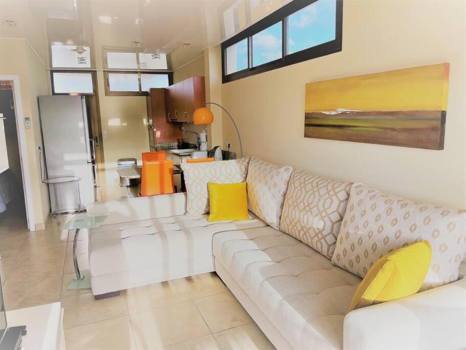 ein Wohnzimmer mit einem weißen Sofa und einer Küche in der Unterkunft Apartment Mananem in Playa del Ingles