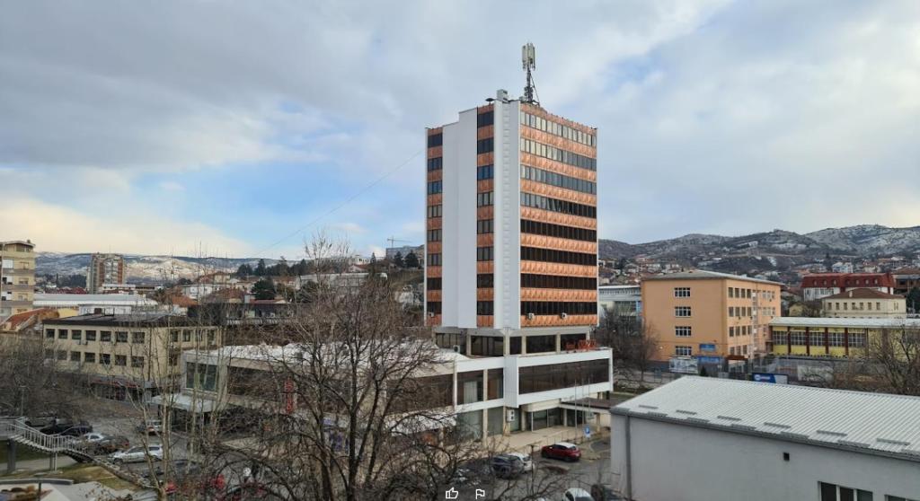 um edifício alto no meio de uma cidade em Oaza Hotel em Stip