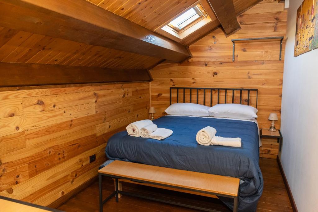 a bedroom in a log cabin with a bed and towels at Case Gemmellaro - Family&Friends in Nicolosi