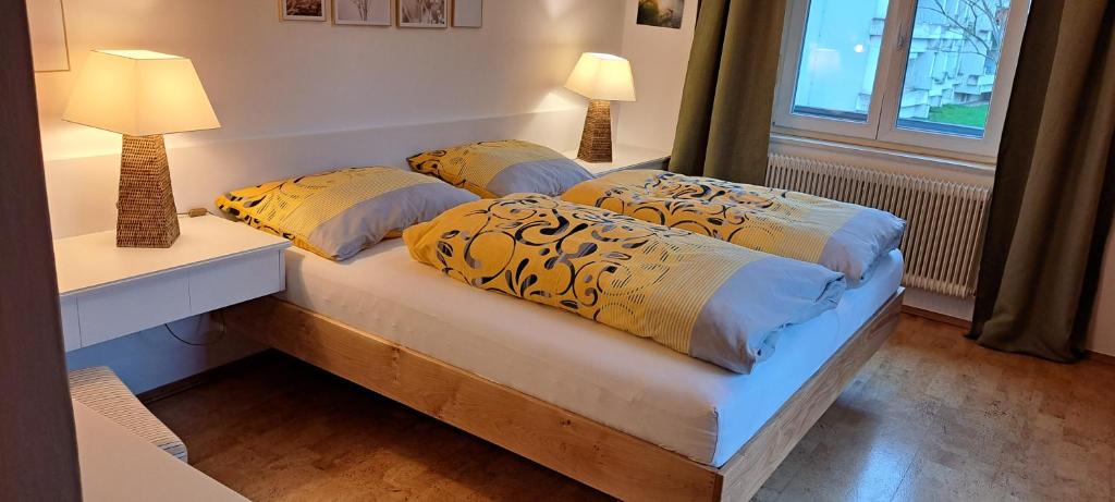 2 camas en un dormitorio con 2 lámparas y una ventana en Haus Pierzinger, en Wörgl