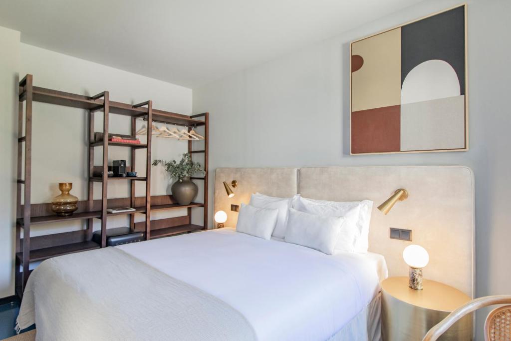 een slaapkamer met een wit bed en een plank bij Regras 45 Building B by LovelyStay in Porto