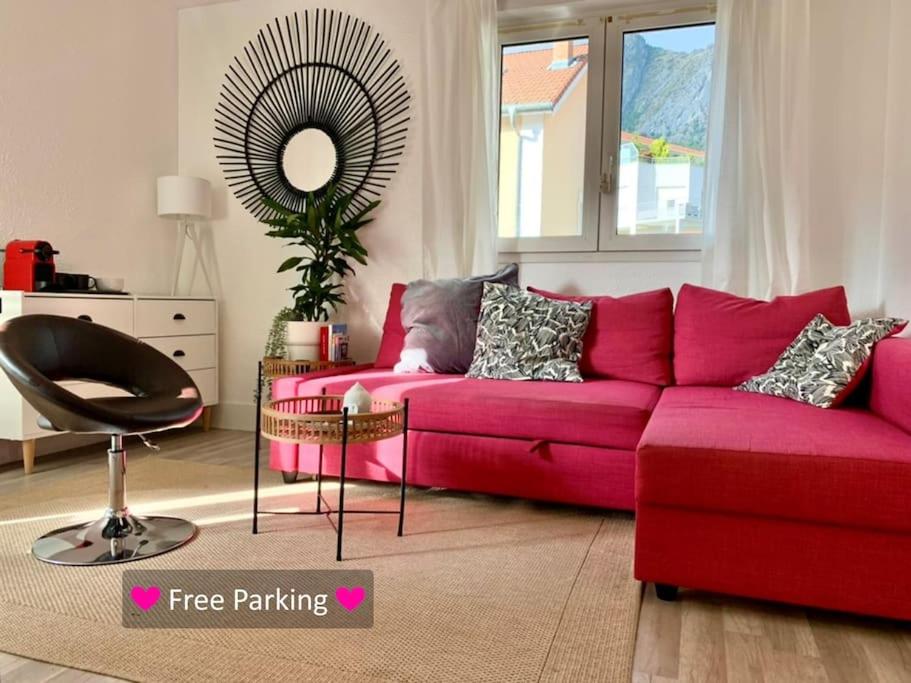 a living room with a red couch and a mirror at Hiker's spot - Parking A/C City Center in Grenoble