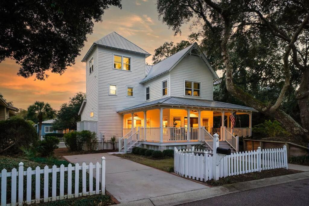 ein weißes Haus mit einem weißen Zaun davor in der Unterkunft Seaside Cottage 81 - Pristine Grand Pavilion Home Pool Pass in Isle of Palms