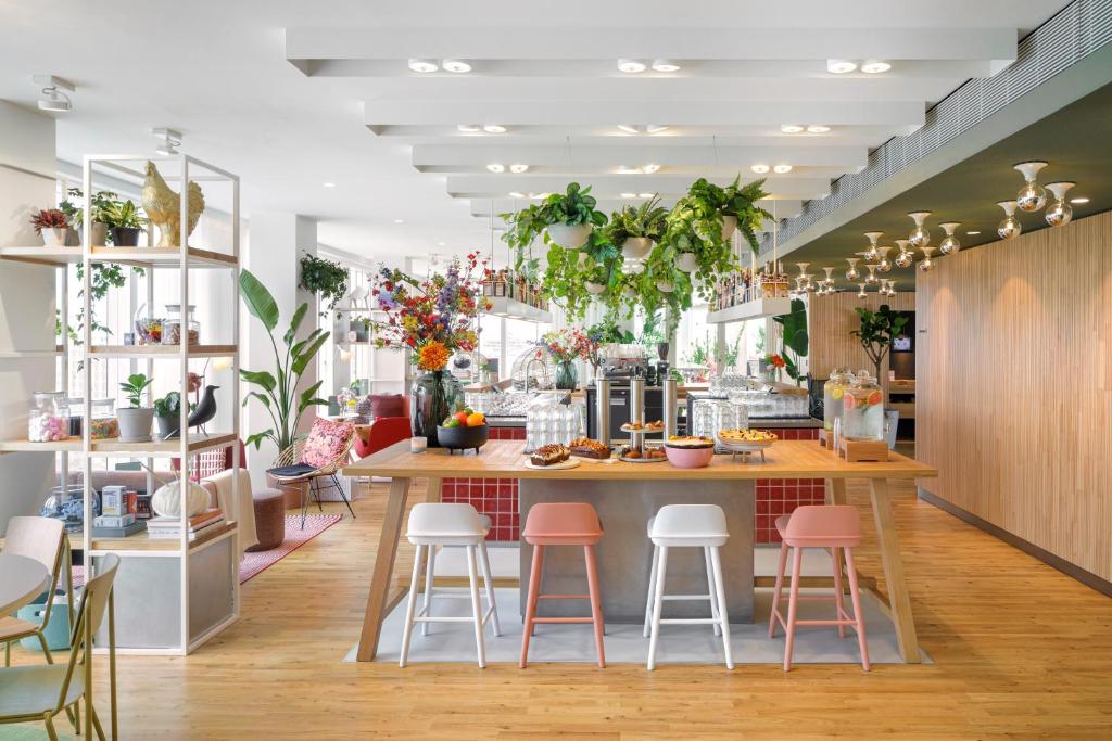 un restaurant avec un comptoir avec des tabourets roses dans l'établissement Zoku Paris, à Paris