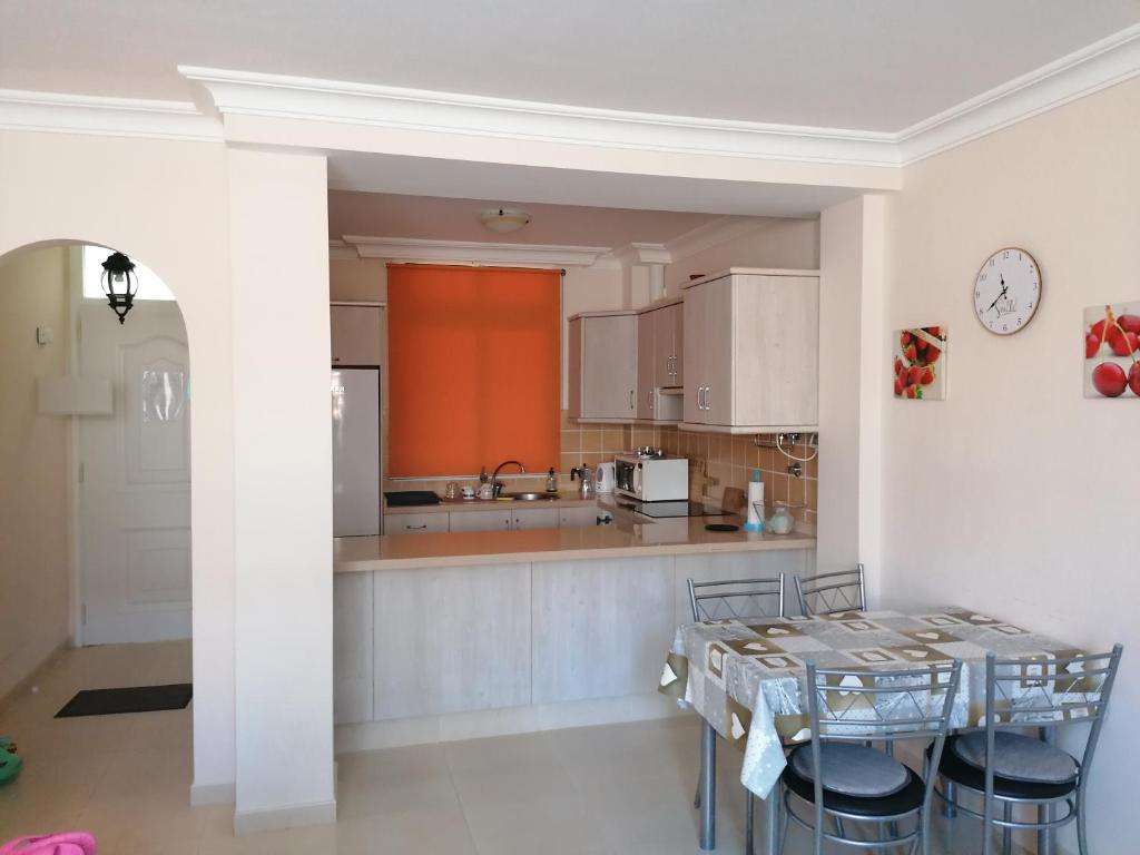 a kitchen with a table and chairs and a counter at Casa Ela in Caleta de Interián