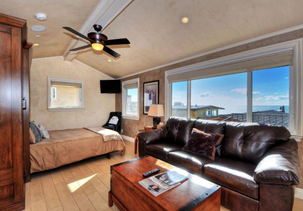 a living room with a leather couch and a bed at Villa D'Arte at the Retreat in Laguna Beach in Laguna Beach