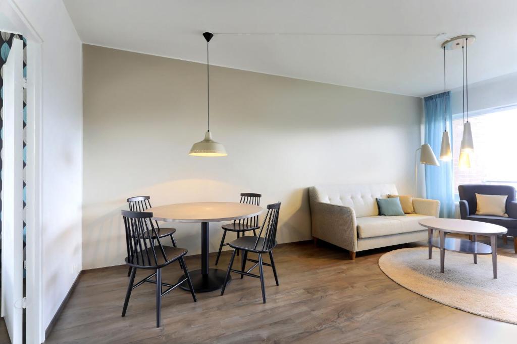 a living room with a table and chairs and a couch at Forenom Serviced Apartments Helsinki Lapinlahdenkatu in Helsinki