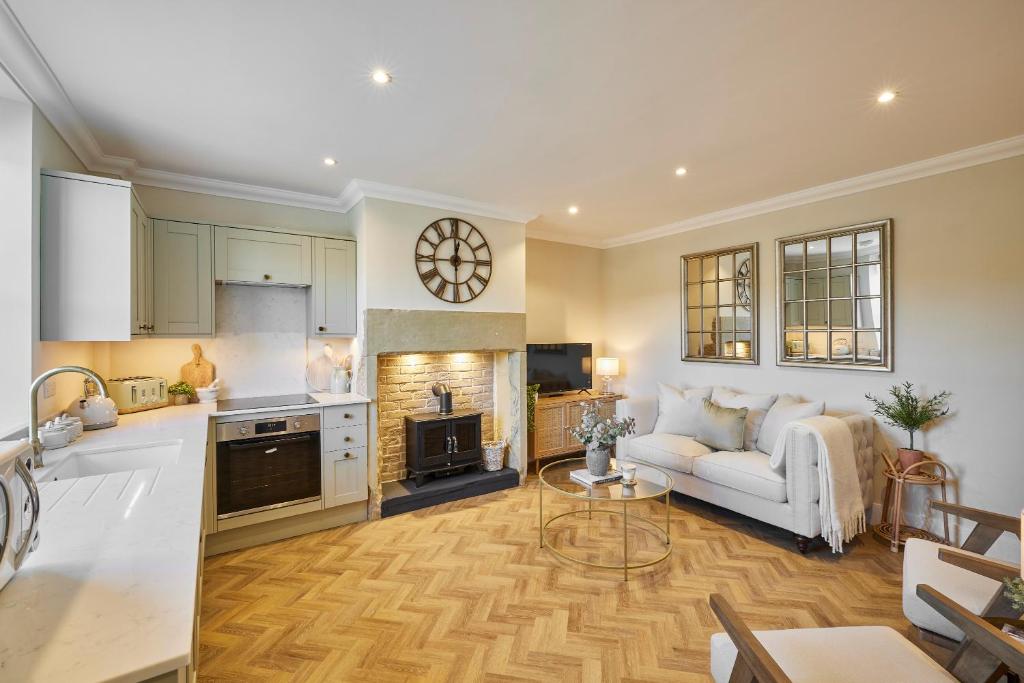 uma cozinha e sala de estar com um sofá e uma mesa em Host & Stay - Oakwell Cottage em Birstall