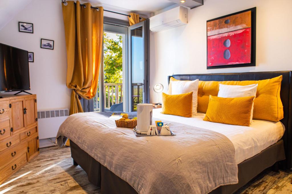 a bedroom with a bed with a laptop on it at Les Terrasses de Saumur - Hôtel & Appartements - Restaurant & Spa (Logis) in Saumur