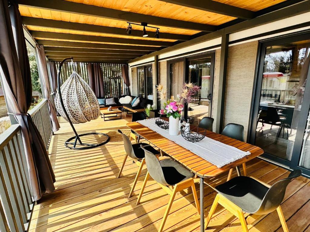 a wooden deck with a table and chairs on it at George Holiday Homes - Soline Beach in Biograd na Moru