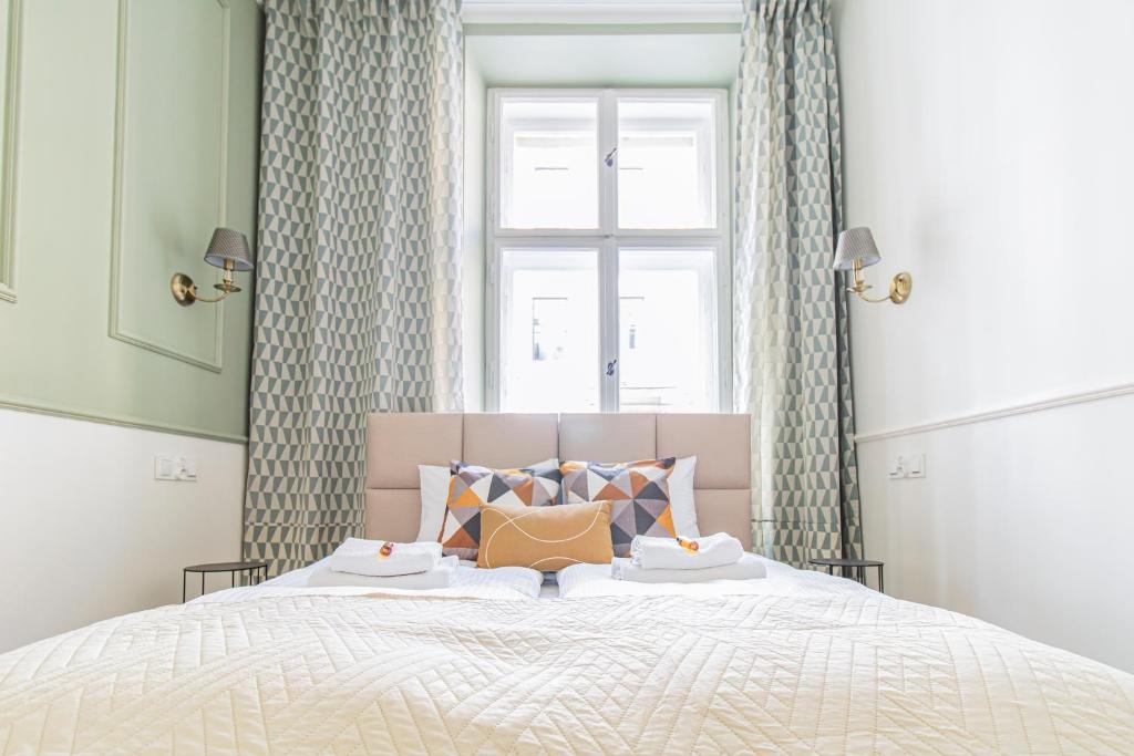 sypialnia z dużym łóżkiem i oknem w obiekcie Modern Apartments Piłsudskiego Street w Krakowie
