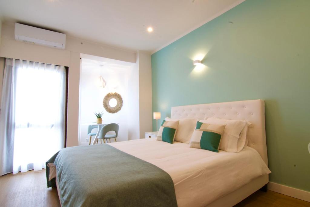 sypialnia z dużym łóżkiem i zielonymi ścianami w obiekcie Sunset Retreat 1a linha de mar w mieście Monte Gordo