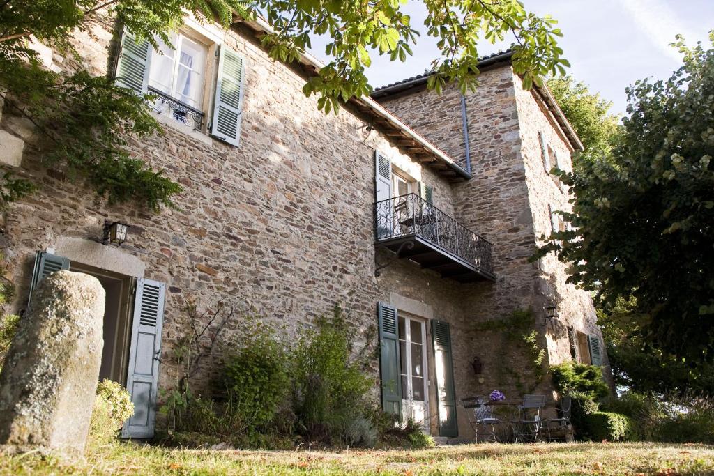 uma antiga casa de tijolos com uma varanda e um alpendre em Chateau De Riverie chambres et table d'hôtes em Riverie