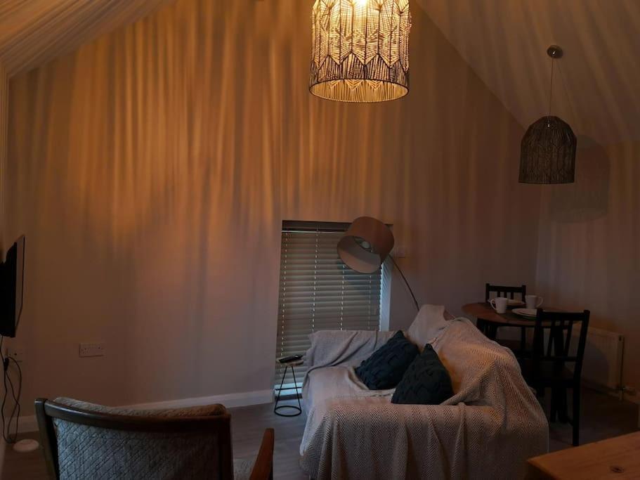 a bedroom with a bed and a lamp and a table at Converted cattle barn overlooking Strangford Lough in Newtownards