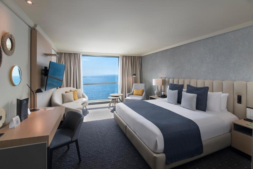 a hotel room with a large bed and a desk at Catalonia Santo Domingo in Santo Domingo