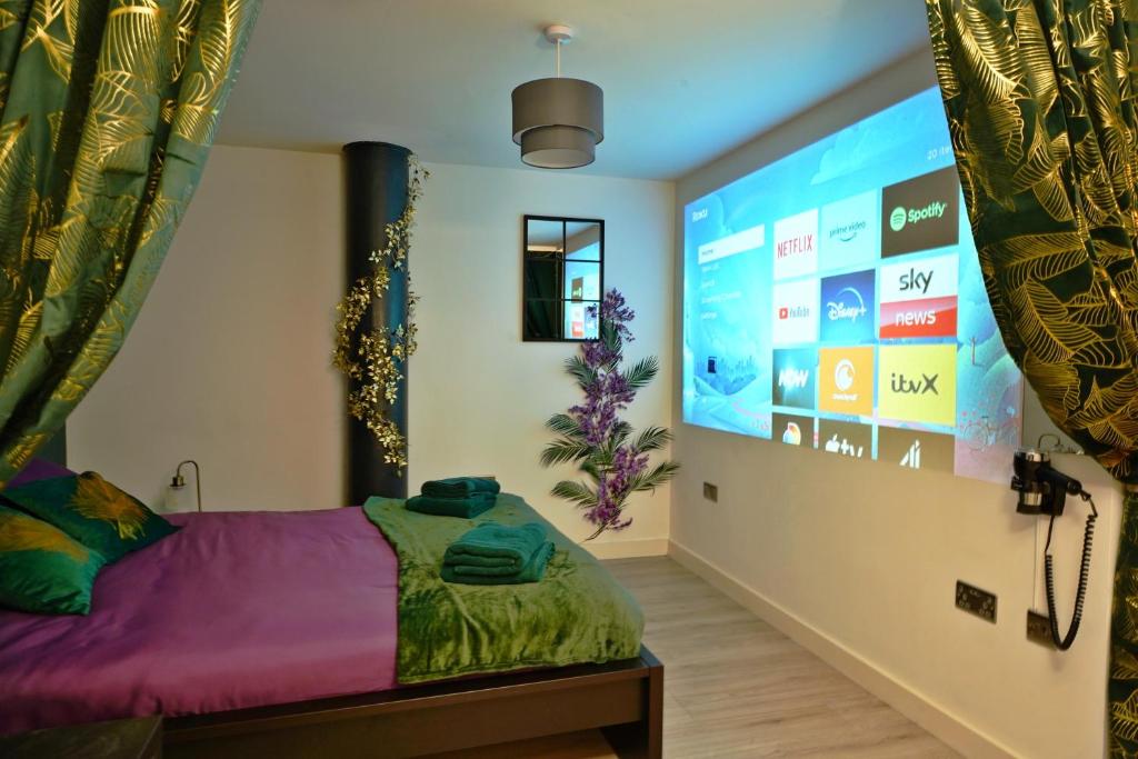 ein Schlafzimmer mit einem Bett und einem großen Bildschirm in der Unterkunft NEW Luxury NYC Style Loft with Cinema Room in Bradford