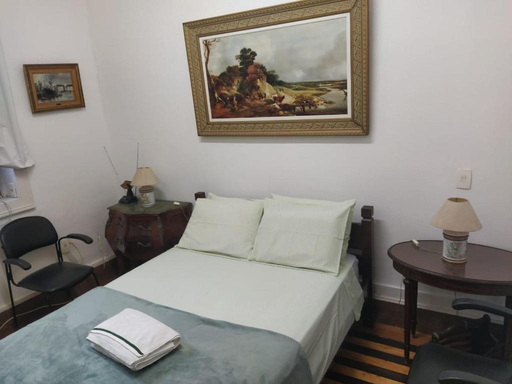 1 dormitorio con 1 cama y una pintura en la pared en Estúdios Deluxe São Manuel, en Río de Janeiro