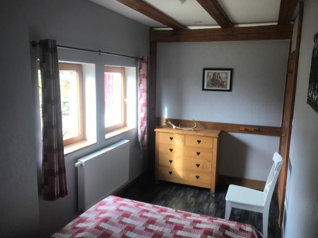 a bedroom with a bed and a dresser and a window at La Petite Finlande in Orbey