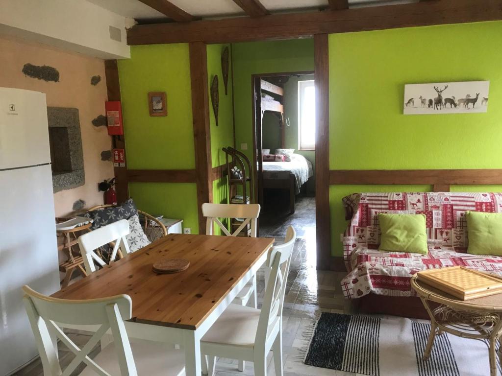 a dining room with green walls and a table and chairs at La Petite Finlande in Orbey