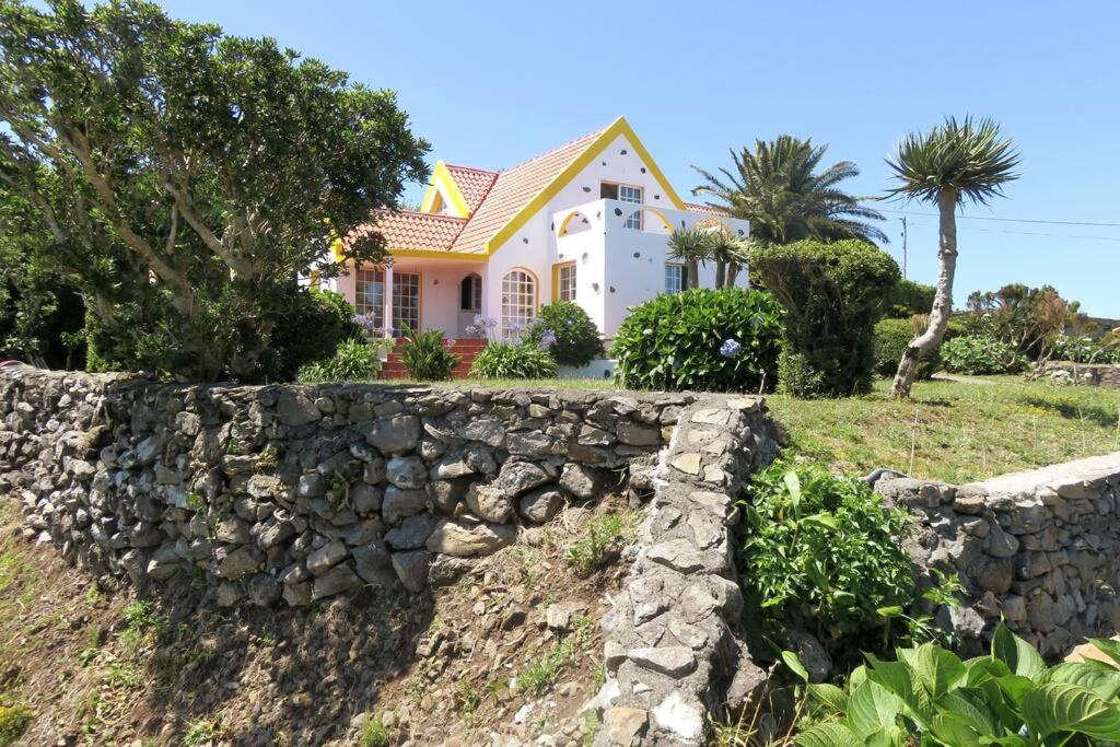 una pared de piedra frente a una casa en Villa Cedros, en Santa Cruz das Flores