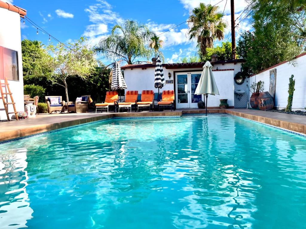 a swimming pool with blue water in front of a house at Casa De Vito in Palm Springs