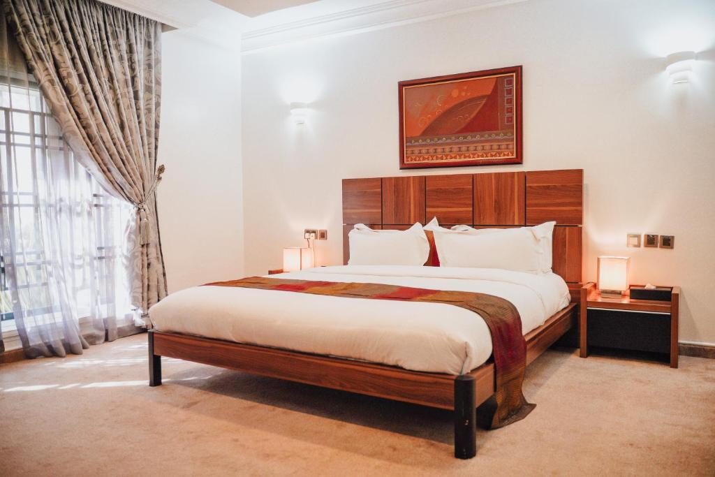 a bedroom with a large bed and a large window at Bricks Point - Boutique Apartments in Abuja