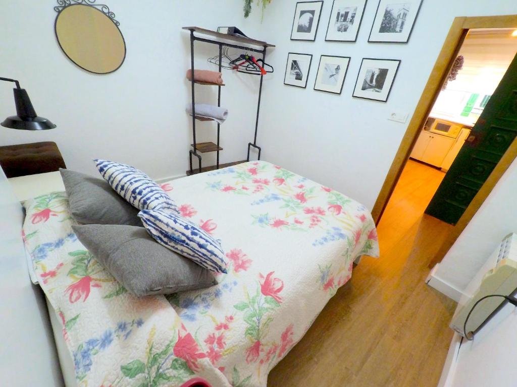 a bedroom with a bed with a flower patterned blanket at Apartamento para 3 en pleno centro de Sevilla in Seville