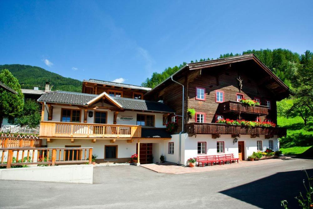 a large house with a porch and a balcony at Appartements Birnbaumer in Matrei in Osttirol