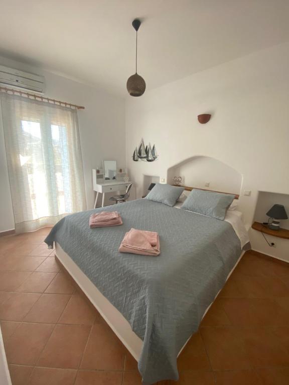 a bedroom with a large bed with two towels on it at Nikos Country House in Naousa