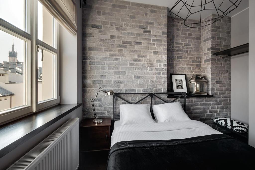 a bedroom with a brick wall and a bed at Too-Good Apartments in Kraków