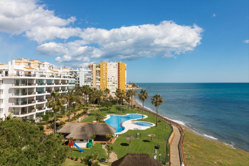 an aerial view of a resort and the ocean at 1 Line Beachfront Apartment with stunning sea view in Sitio de Calahonda