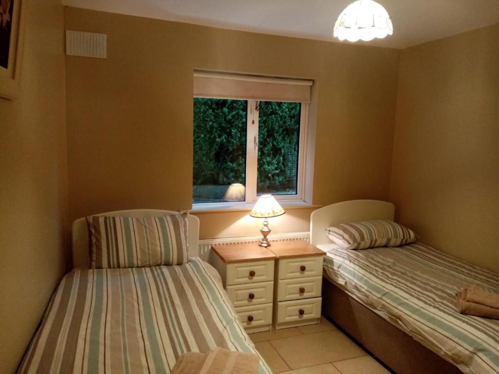 2 camas individuales en un dormitorio con ventana en 33A Steepleview, en Trim