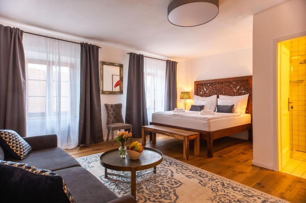 pokój hotelowy z łóżkiem i kanapą w obiekcie Pension Adalbert w Czeskim Krumlovie