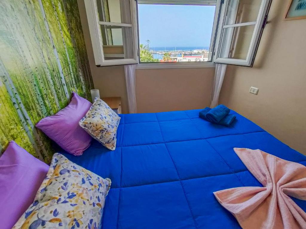 een blauw bed in een kamer met 2 ramen bij Precioso apartamento en Los Cristianos in Los Cristianos